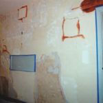 This wall is receiving repairs, reattachment and infill. The pink areas are bonding agent applied so the new plaster will adhere.